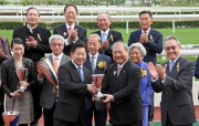 Kuok Hoi Sang, Vice Chairman & Managing Director of Chevalier International Holdings Limited, presents a trophy to winning trainer Dennis Yip.