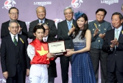 Ms Chiling Lin, LONGINES Ambassador of Elegance, presents a LONGINES Conquest Classic Moonphase watch to Yuichi Fukunaga, winner of the LONGINES International Jockeys' Championship.
