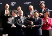 香港賽馬會董事鄭維志博士（右）頒發騎師駿馬銅像給浪琴表香港瓶冠軍「富林特郡」的馬主代表。