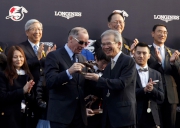 The Hon Lam Woon Kwong (right), Convenor of the Non-official Members of the Executive Council of the HKSAR, presents a bronze statuette of a horse and jockey to John Moore, trainer of Designs On Rome.