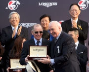 Mr Walter von Kanel (right), President of LONGINES International, presents a souvenir to Designs On Rome��s trainer John Moore.