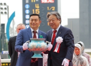 Masayuki Goto (right), President and CEO of Japan Racing Association, presents the trophy of the Takamatsunomiya Kinen to Daniel Yeung Ngai, owner of Aerovelocity.