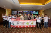 HKJC Chairman Dr Simon Ip (front row, in grey suit), CEO Winfried Engelbrecht-Bresges (front row, in dark suit), and owner Daniel Yeung of KrisFlyer International Sprint runner AEROVELOCITY (front row, in beige suit), take a group photo together with the Hong Kong cheering team before the two big races being held at Kranji tonight.