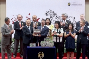中央人民政府駐香港特別行政區聯絡辦公室副主任楊健（左），將國慶盃的獎盃頒發予勝出馬匹「新力風」的馬主黃良柏。