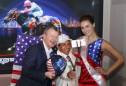 Triple Crown winning jockey Victor Espinoza takes a selfie on stage with Mr. Winfried Engelbrecht-Bresges and the racing ambassador in USA National Flag costume.