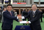 Mr. Masayuki Goto, President and Chief Executive Officer of the Japan Racing Association (right), presents a prize of HK$5,000 to the groom responsible for Fiero, the Best Turned Out Horse in the LONGINES Hong Kong Mile.