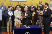 Chairman of the Oriental Watch Holdings Limited Dr Yeung Ming Biu, accompanied by his wife (front row, right), presents a souvenir to the owner representative of Design On Rome.