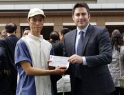 Before the race, Zane Turner, Chief Stipendiary Steward of the Macau Jockey Club, presents a prize of HK$1,500 to the Stable Assistant responsible for Invincible Dragon, the Best Turned Out Horse in the Hong Kong Macau Trophy.