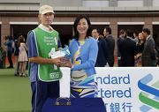 Before the race, Mary Huen, Chief Executive Officer, Standard Chartered Bank (Hong Kong) Limited, presents a HK$5,000 prize and a souvenir to the Stables Assistant responsible for Werther, the best turned out horse for the Standard Chartered Champions & Chater Cup.
